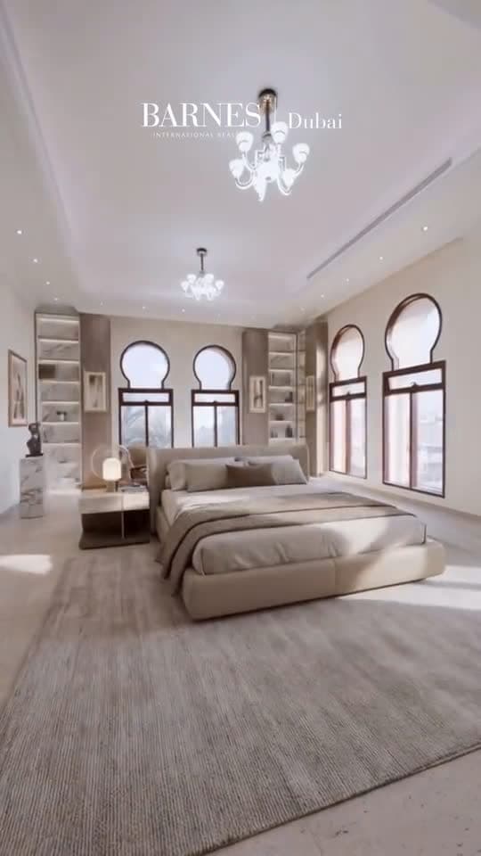 The same bedroom from the same position, furnished: a low upholstered bed, a rug, side tables and shelving.