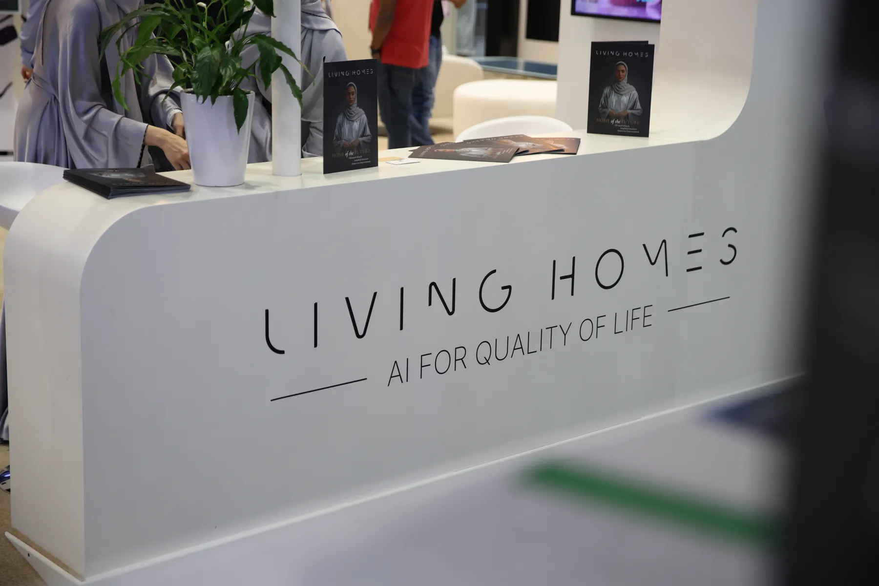 Stand reception desk carrying the Living Homes wordmark and the line AI for quality of life.